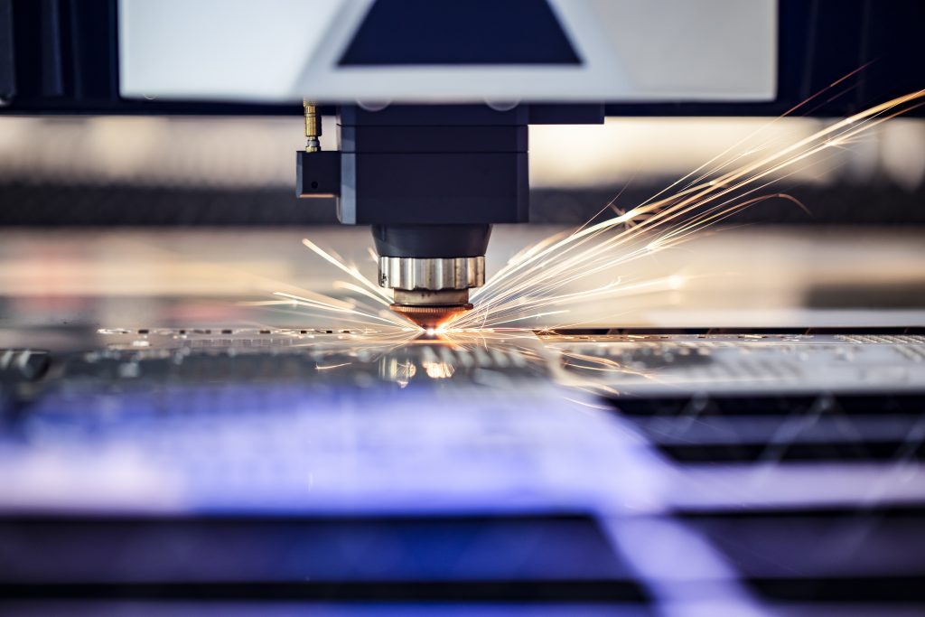 CNC laser cutting through thin sheet metal.